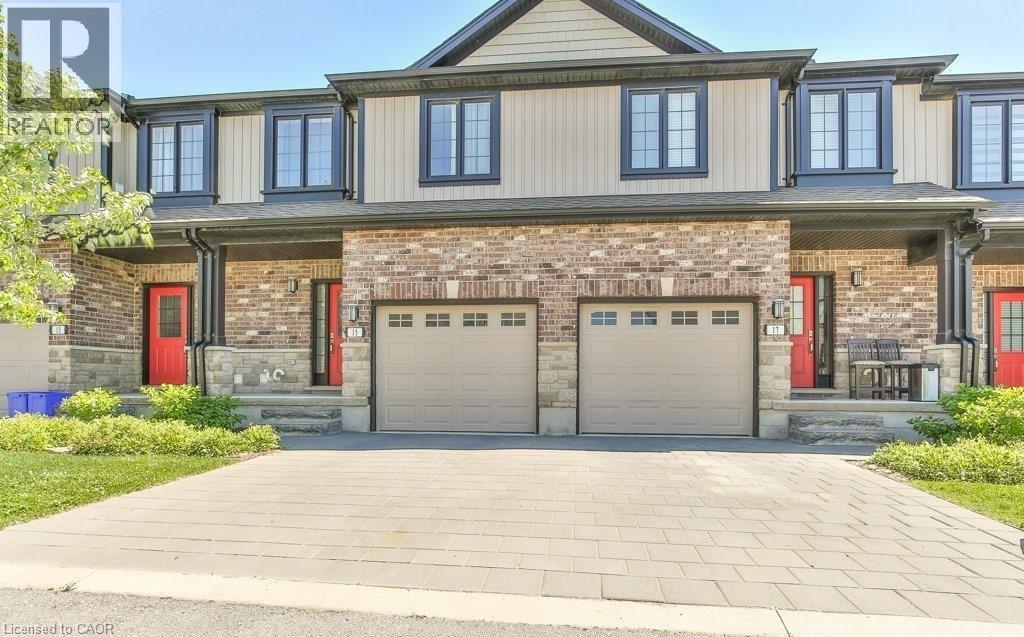 A two-story house with a red door and garage doors.
