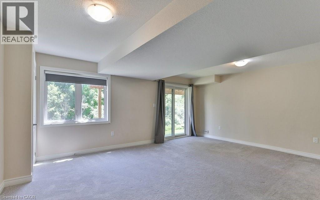 A spacious room with a window and sliding glass doors.