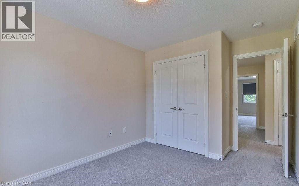 A bedroom with a white door and carpeted floor.