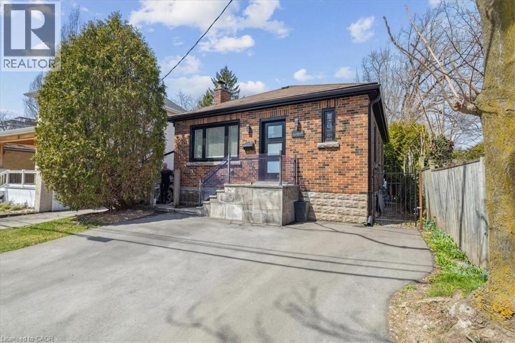 A small brick house with a driveway in front.