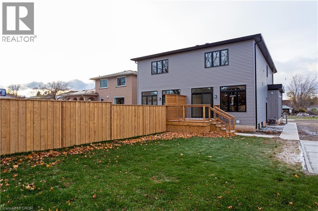 A house with a grey exterior and a wooden fence in front.