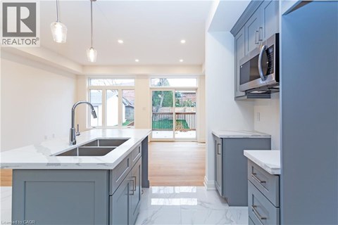 A modern kitchen with a sink and a microwave.