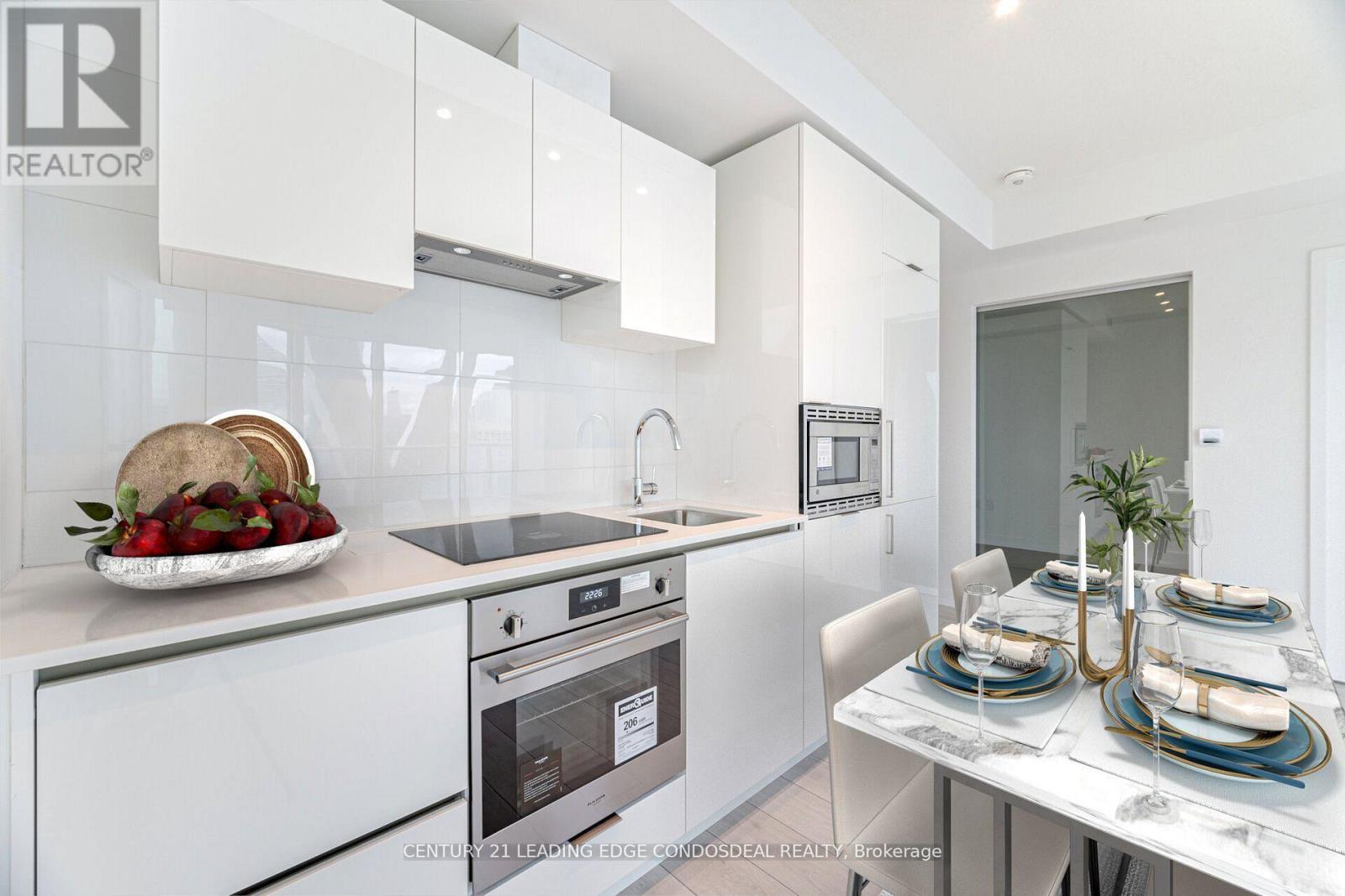 A modern kitchen with white appliances and a dining table set for two.