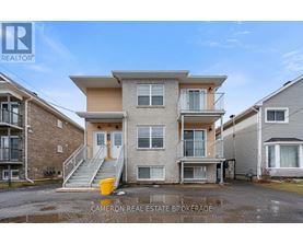 A real estate brokerage photo of a two-story townhouse with a balcony and a garage.