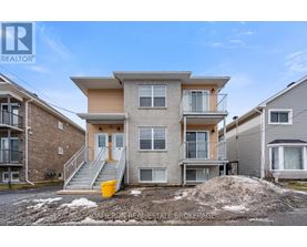A real estate brokerage photo of a two-story townhouse with a balcony and a garage.