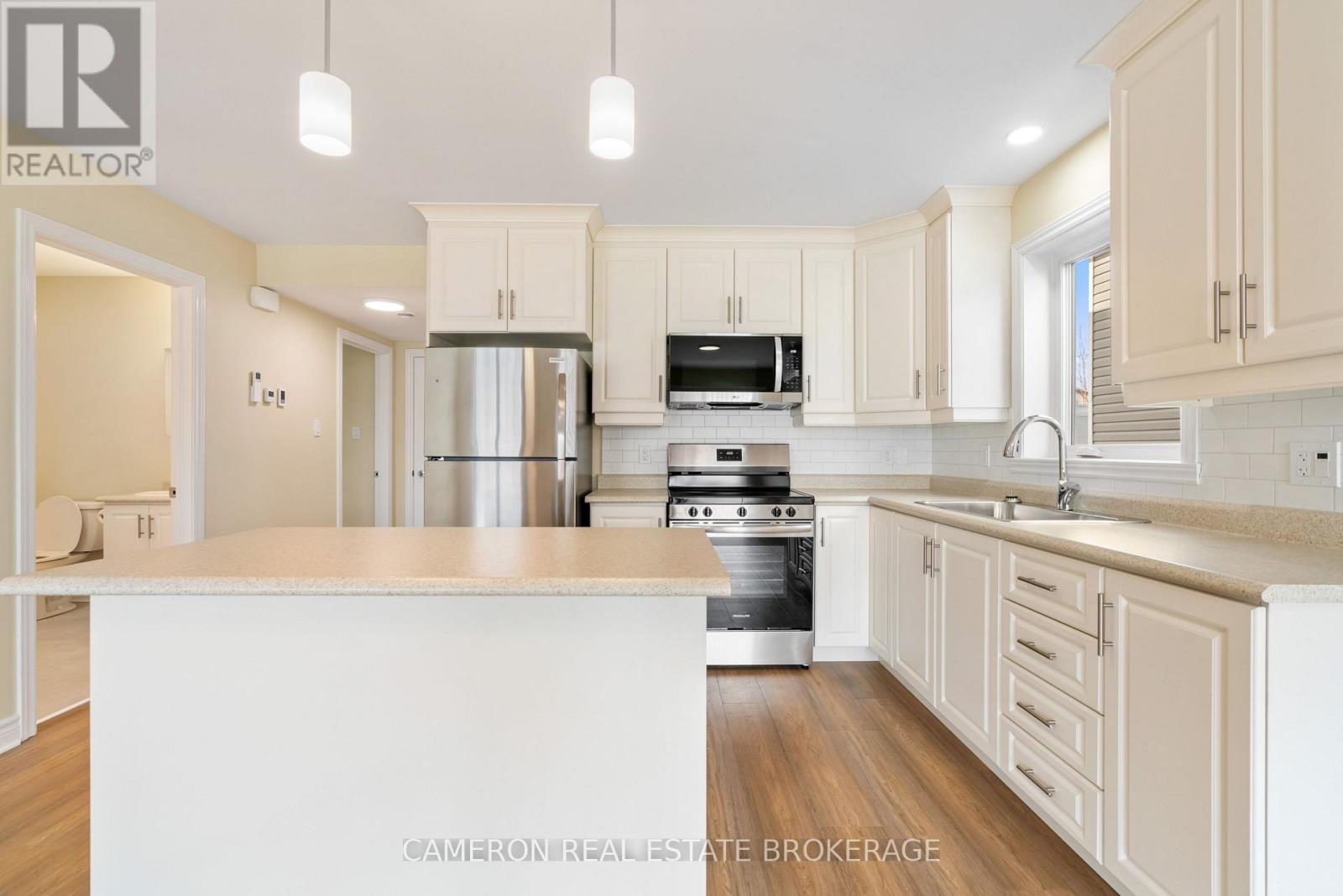 A kitchen with white cabinets and a white island.