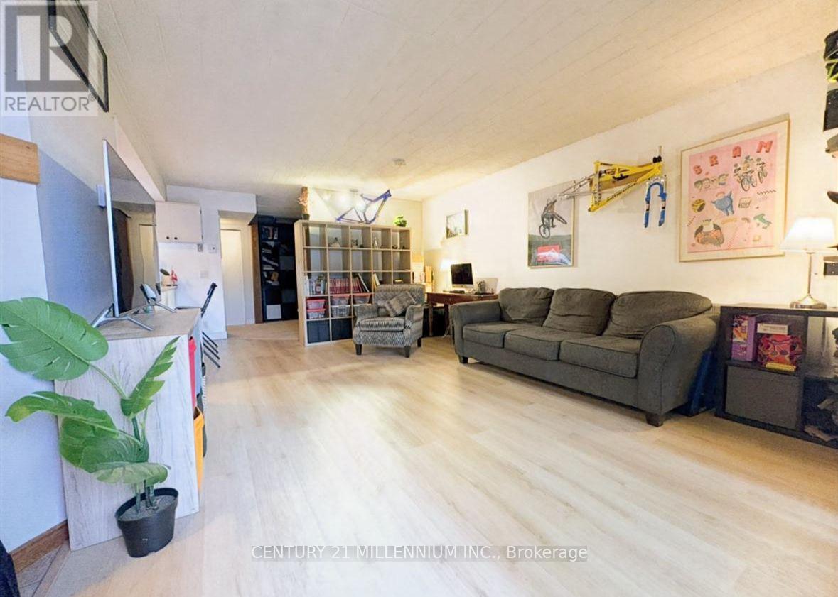 A living room with a grey couch and a wooden floor.