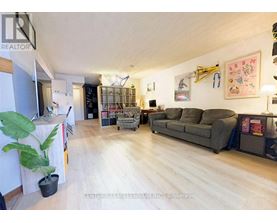 A living room with a grey couch and a wooden floor.