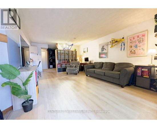 A living room with a grey couch and a wooden floor.