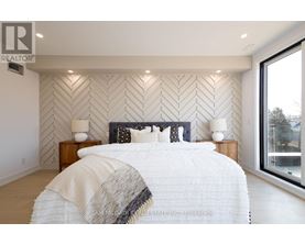 A bedroom with a large bed and a wall with a herringbone pattern.