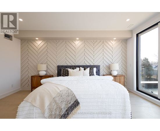A bedroom with a large bed and a wall with a herringbone pattern.