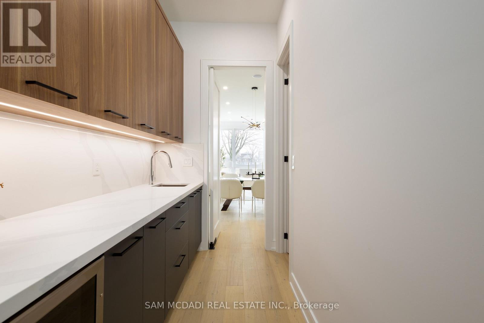 A kitchen with a white counter top and wooden cabinets.