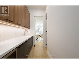 A kitchen with a white counter top and wooden cabinets.