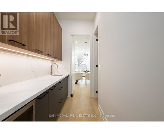 A kitchen with a white counter top and wooden cabinets.