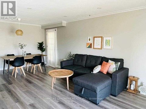 A living room with a black couch and a wooden coffee table.