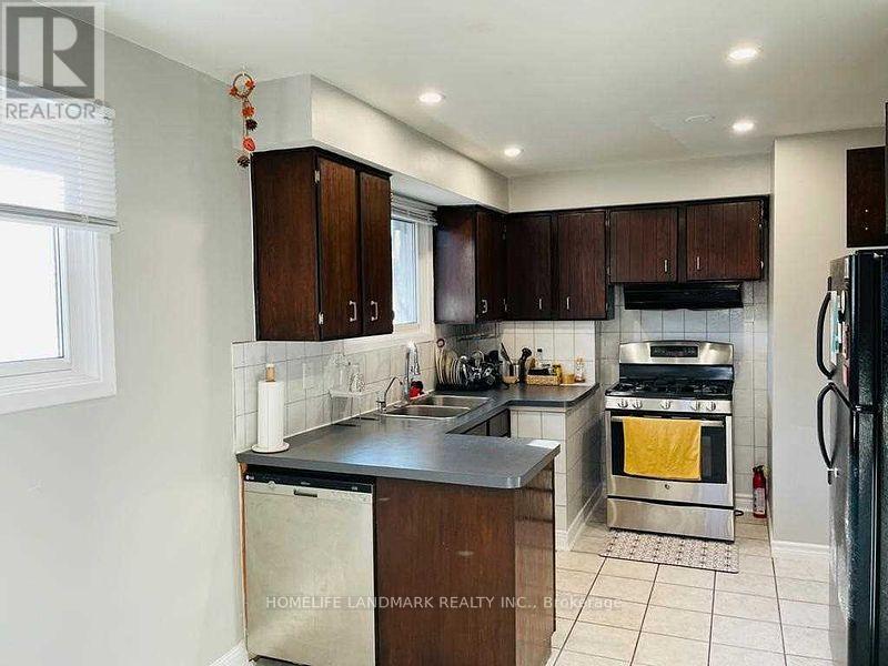 A kitchen with a refrigerator on the right side.