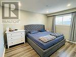 A bedroom with a bed, nightstand, and window.