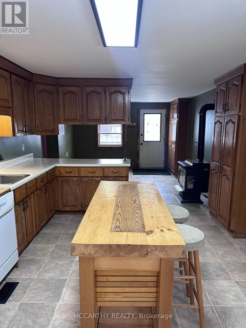A kitchen with wooden cabinets and a wooden table.
