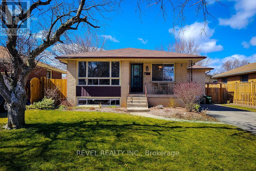 A house with a brown roof and a tree in front of it.