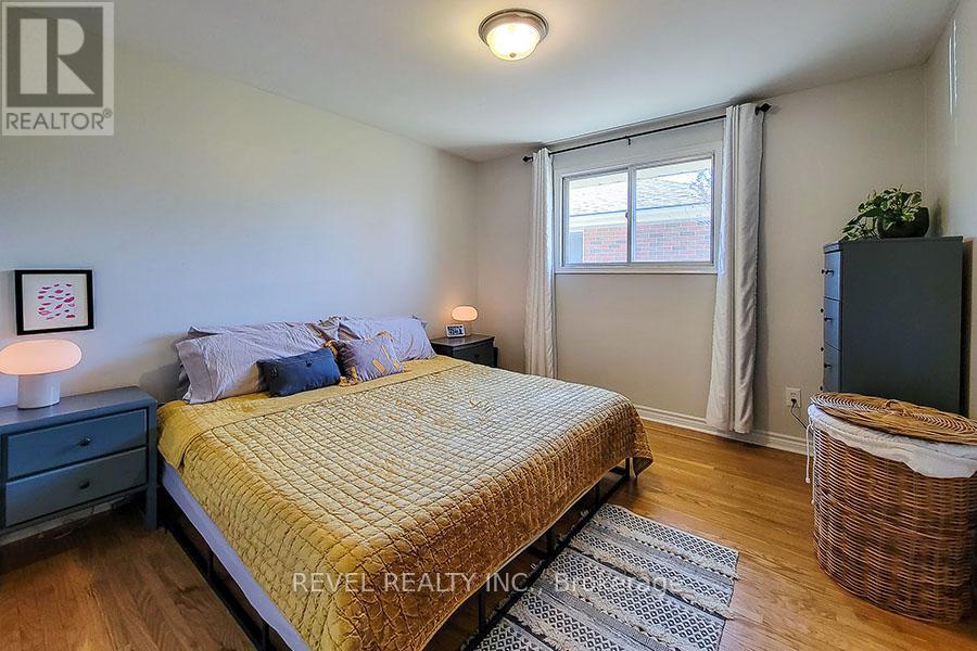 A bedroom with a bed, nightstand, and window.