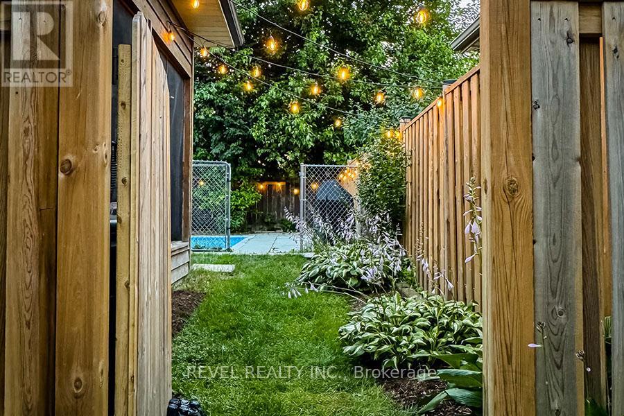 A backyard with a pool and a wooden fence.