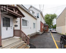 A white house with a brown door and a sign that says RE/MAX Hallmark Realty Group.
