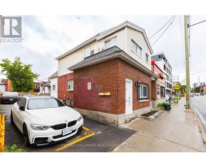 A white BMW is parked in front of a red brick building.