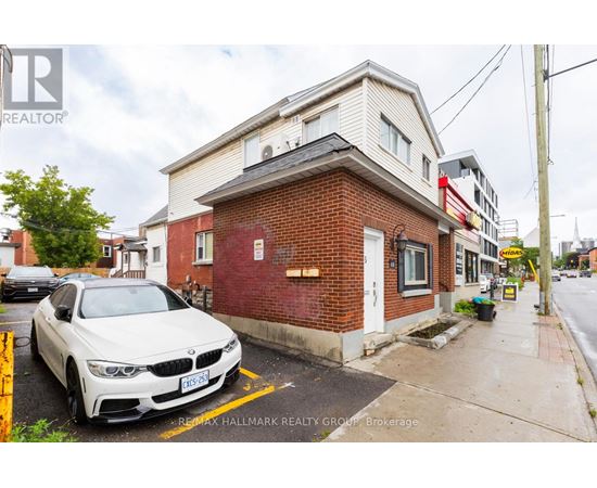 A white BMW is parked in front of a red brick building.