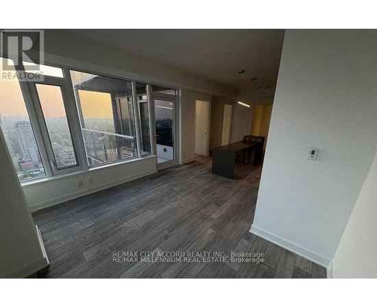 A room with a view of the city through large windows.