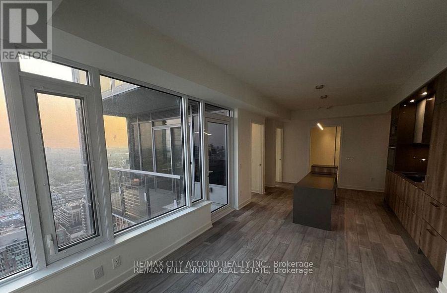 A room with a view of the city through large windows.