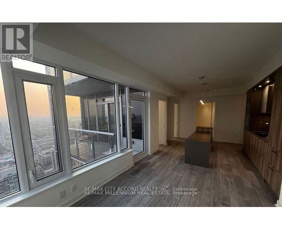 A room with a view of the city through large windows.