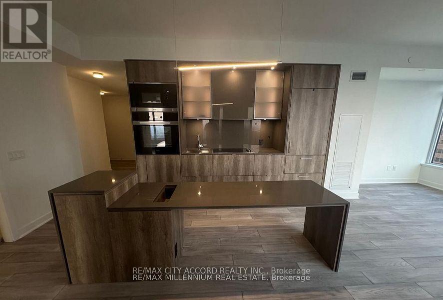 A modern kitchen with a wooden island and stainless steel appliances.