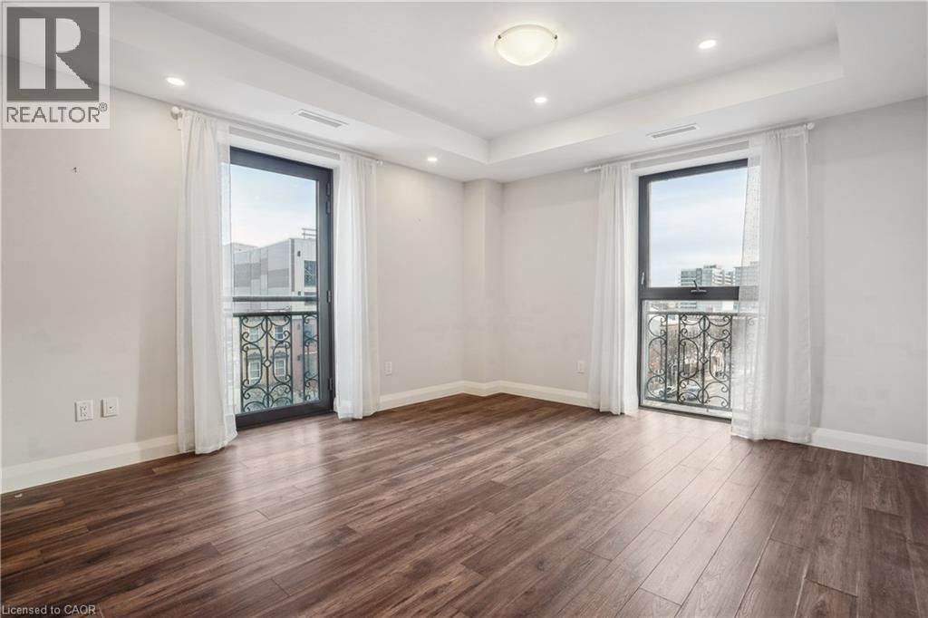 A spacious room with wooden flooring and white walls.