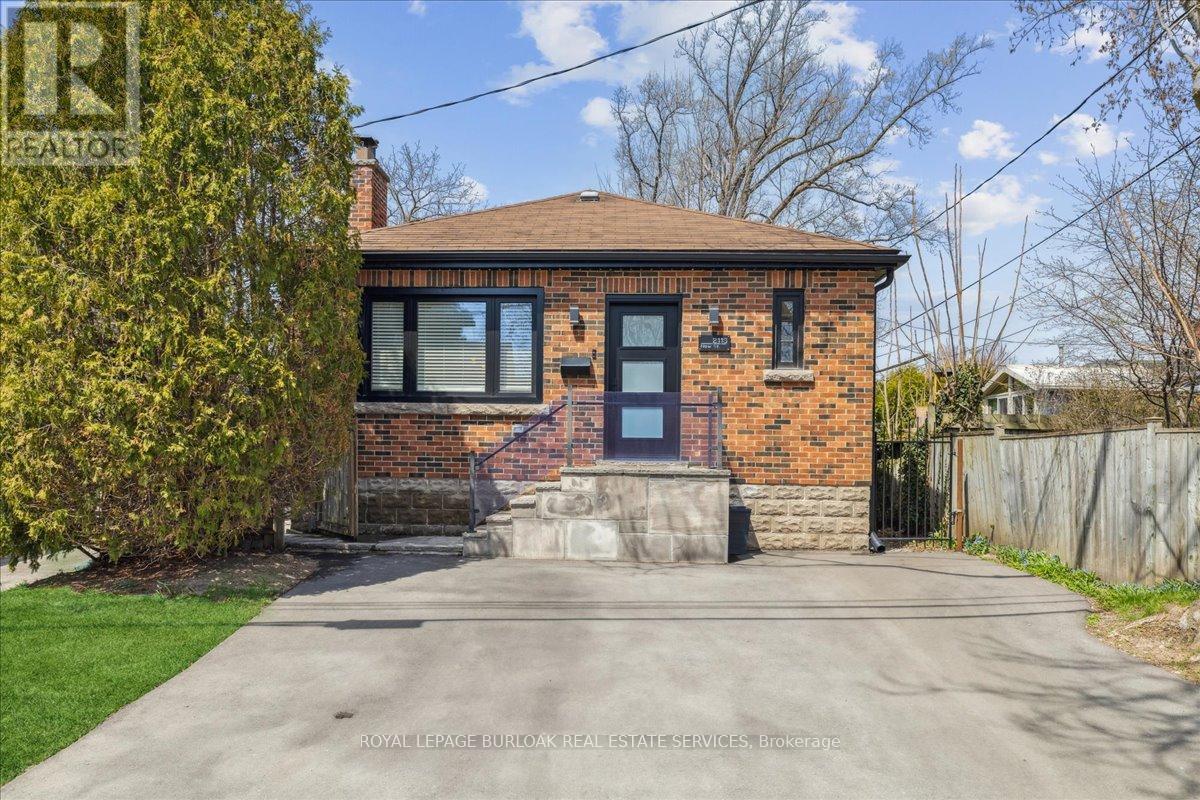 A house with a brown brick exterior and a white window is for sale.