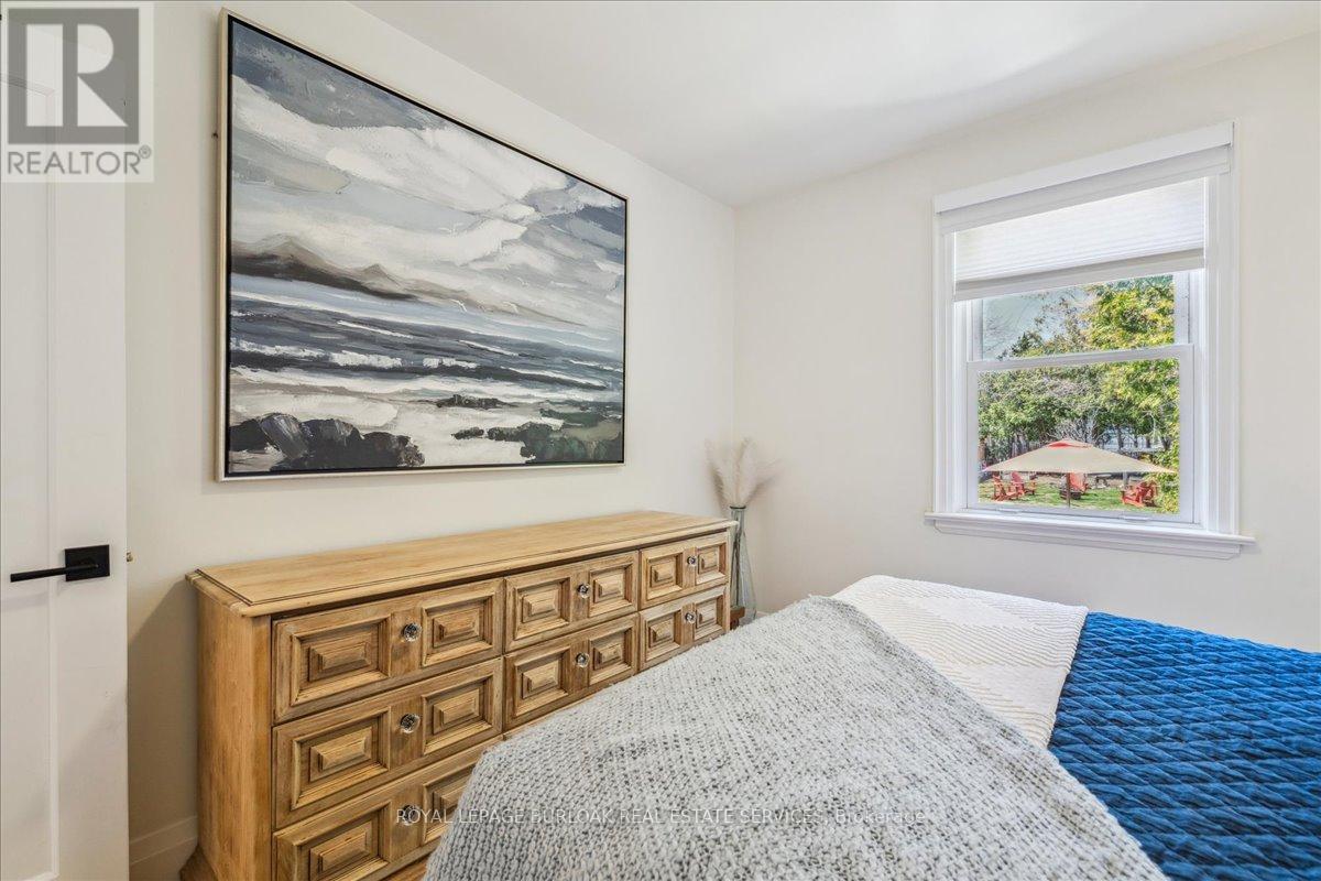 A bedroom with a large bed and a painting on the wall.