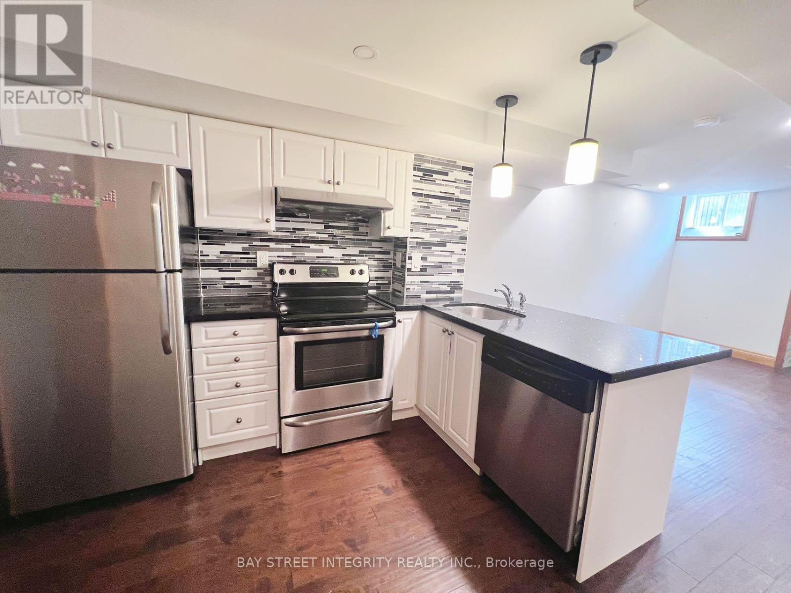 A kitchen with white cabinets and a black countertop.