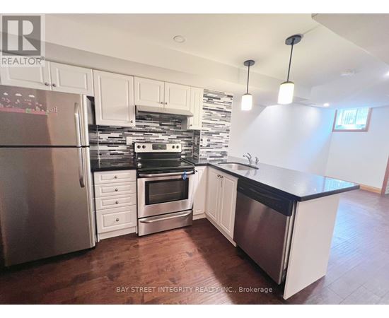 A kitchen with white cabinets and a black countertop.