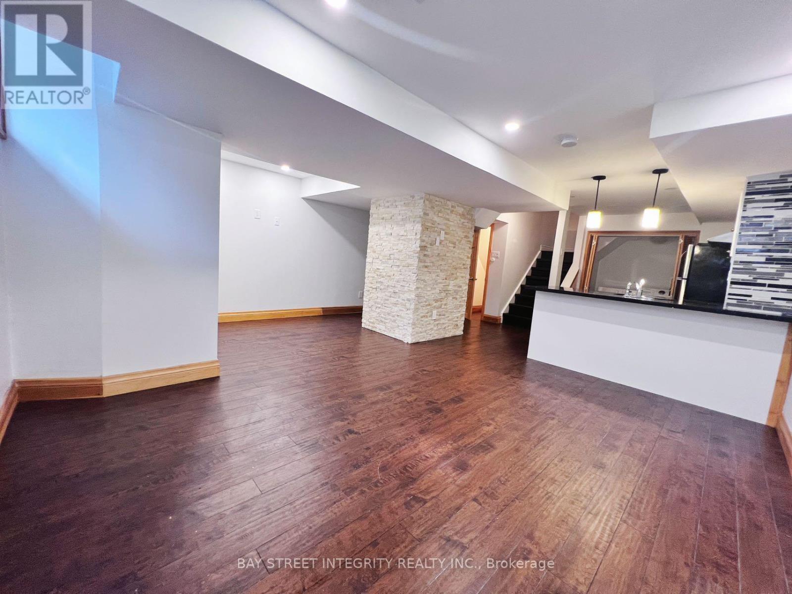 A spacious room with wooden flooring and a reception desk.