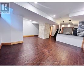 A spacious room with wooden flooring and a reception desk.