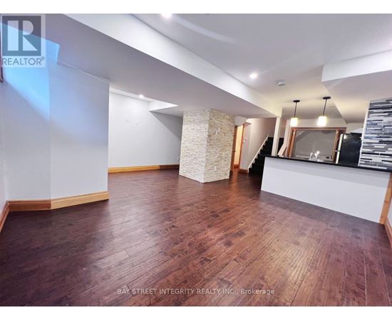 A spacious room with wooden flooring and a reception desk.
