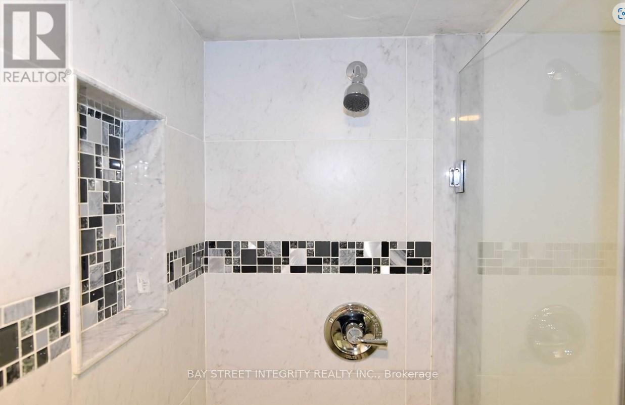 A white bathroom with a shower and a tile border.