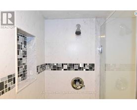 A white bathroom with a shower and a tile border.