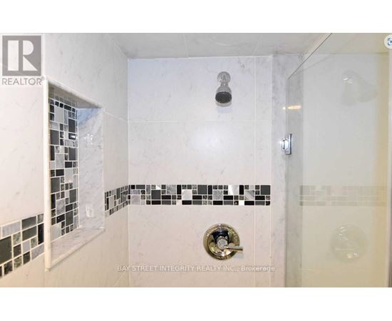 A white bathroom with a shower and a tile border.