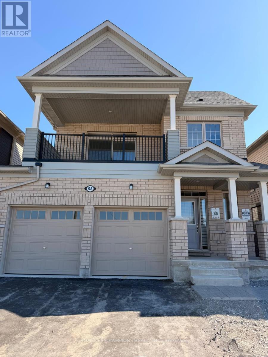 A two-story house with a balcony and two garage doors.