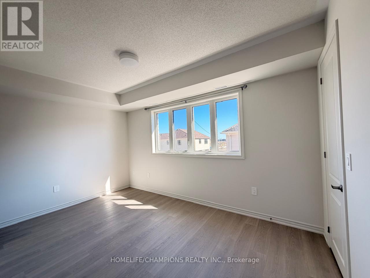 A room with a window showing a view of a building outside.