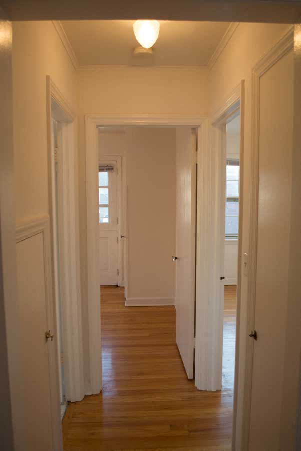 a hallway with white doors and a wood floor