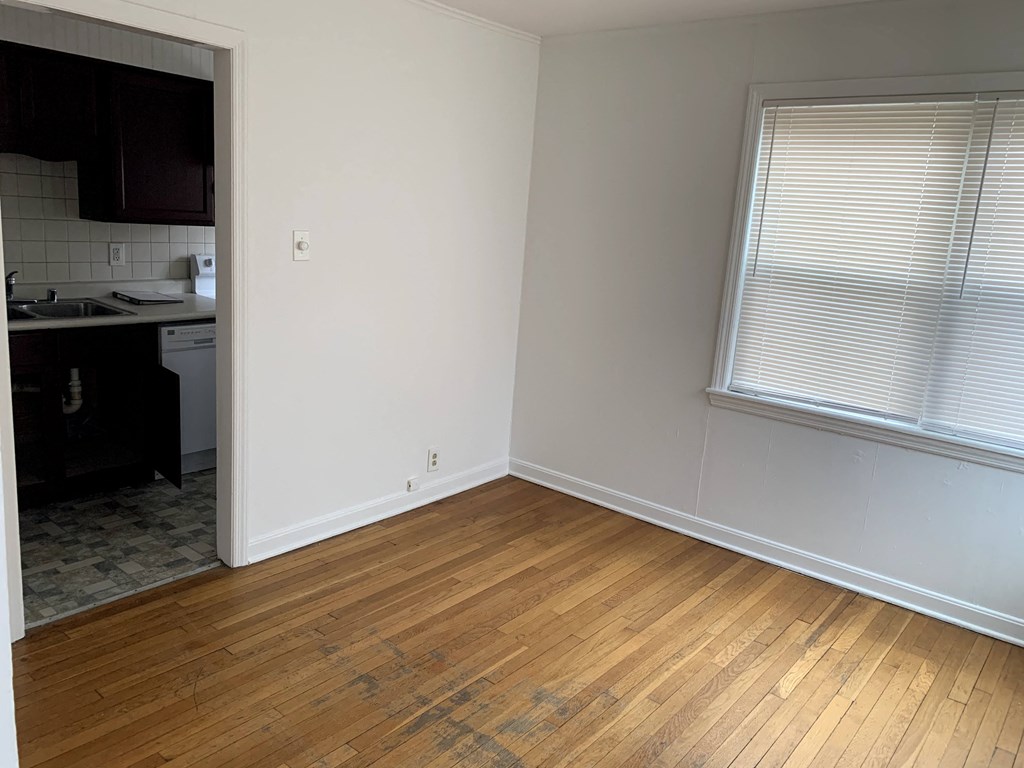 an empty room with wood floors and a window
