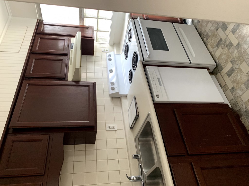 an aerial view of a kitchen with white appliances and brown cabinets