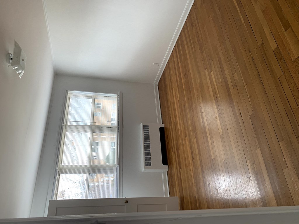 a room with wood flooring and a window