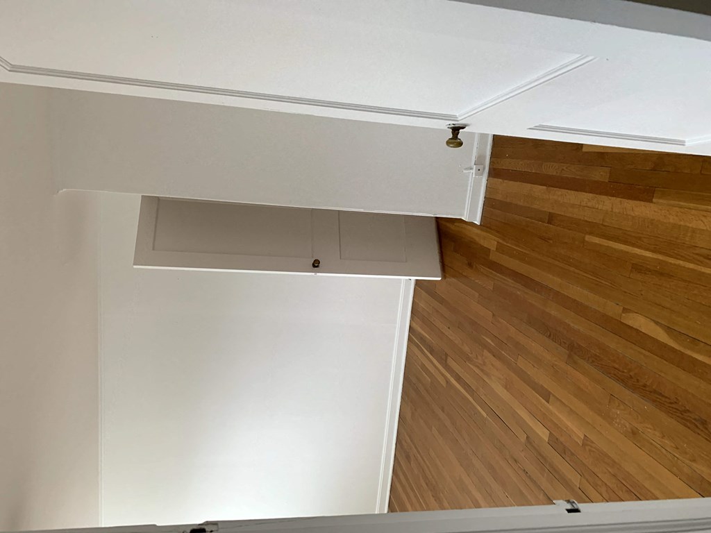 an overhead view of a kitchen with white cabinets and wood floors